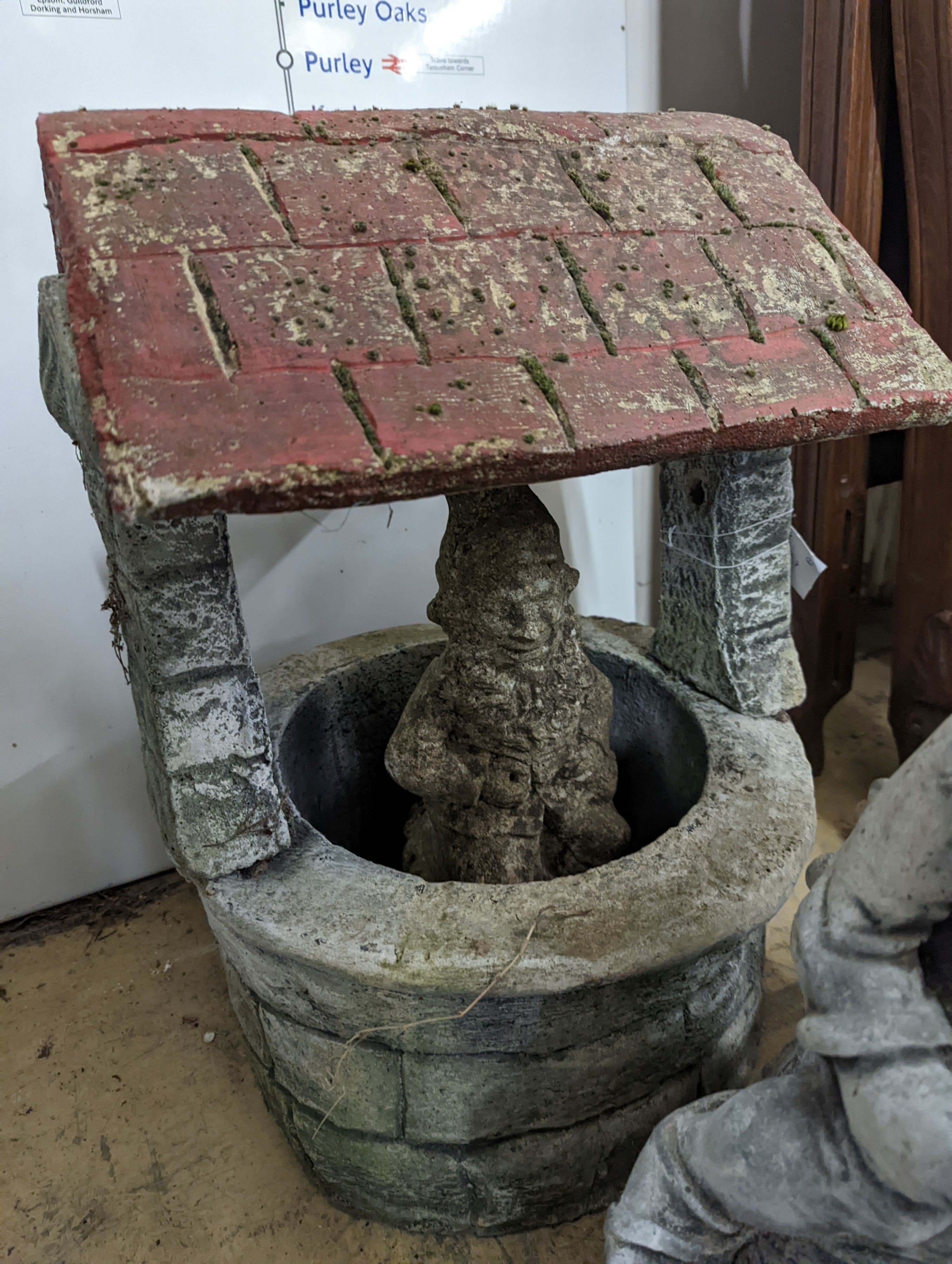 A reconstituted stone well garden ornament and two stone garden gnome ornaments, largest height 50cm